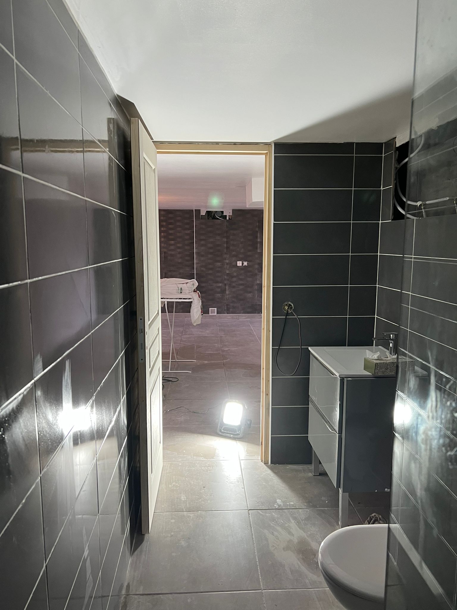 Salle d'eau rénovée avec carrelage sombre